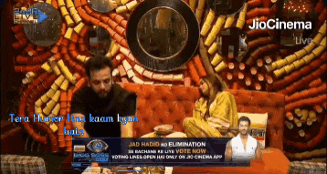 a man and a woman are sitting on a couch in front of a sign that says jiocinema live