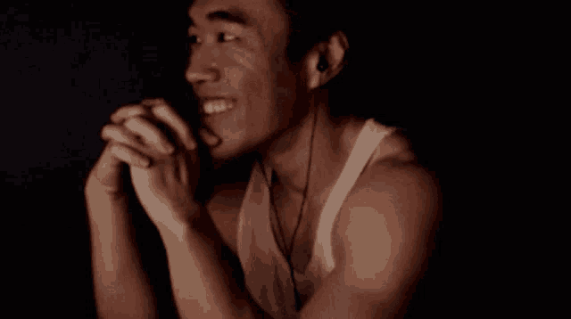a man wearing headphones and a white tank top