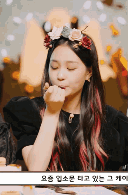 a girl with a flower crown on her head is eating