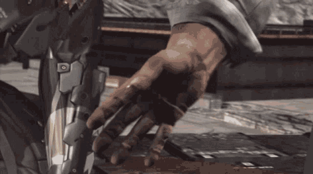 a close up of a person 's hand reaching out towards a robotic arm