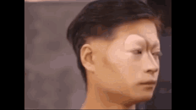 a close up of a man 's face with makeup on it and a fake eyebrow .