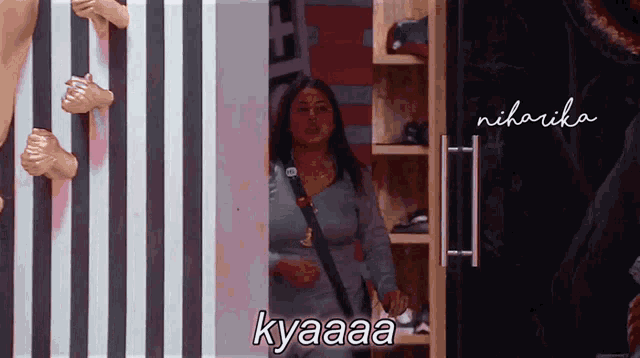 a woman is standing in front of a striped wall with the words kyaaaa written on it