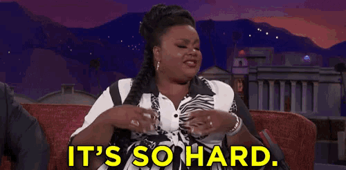 a woman is sitting on a couch with the words `` it 's so hard '' written on the screen .