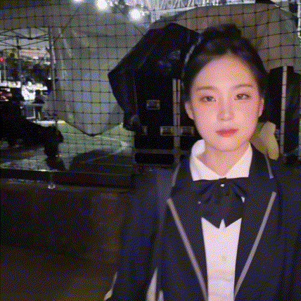 a woman wearing a suit and bow tie is standing in front of a net