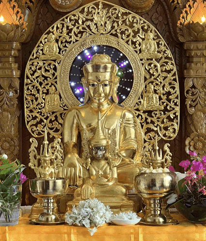 a gold statue of a buddha sitting on a throne
