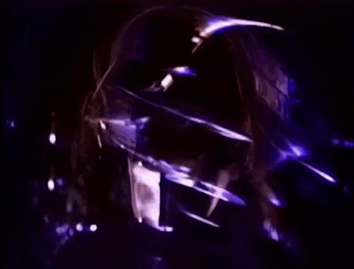 a close up of a person 's face with a purple light behind it .