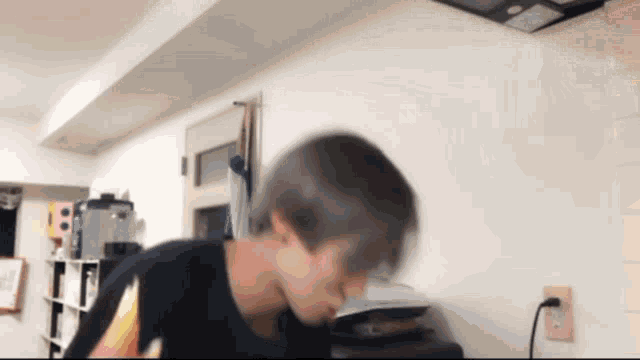 a blurry picture of a person 's face with a white wall behind them