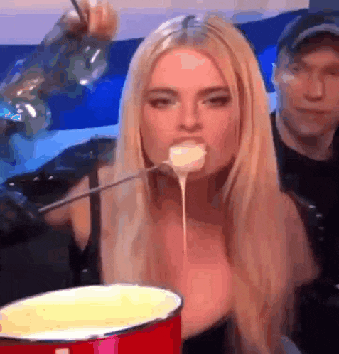 a woman is eating a fondue with a fork .