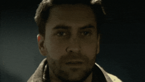 a man with a beard is looking down at something