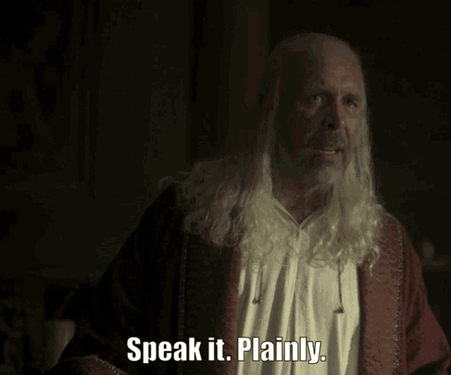 a man with long white hair and a beard says " speak it plainly "