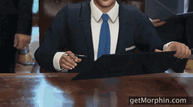 a man in a suit and tie sits at a desk with a pen in his hand