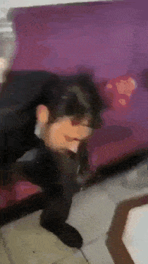 a blurry image of a person sitting on a couch