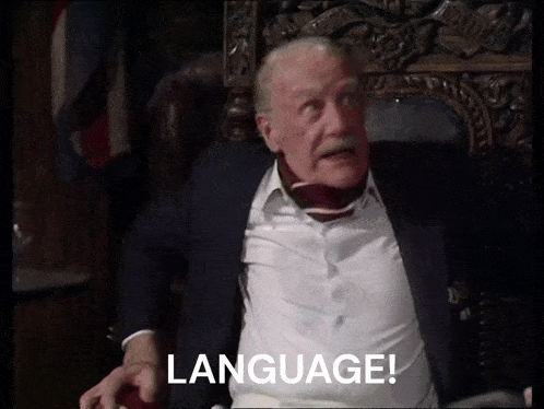 a man in a suit is sitting in a chair with the word language written on the screen