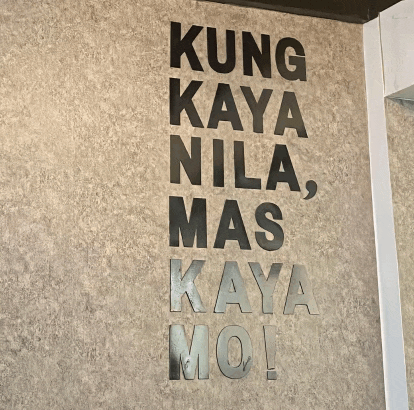 a sign on a wall says kung kaya nila mas kaya moi