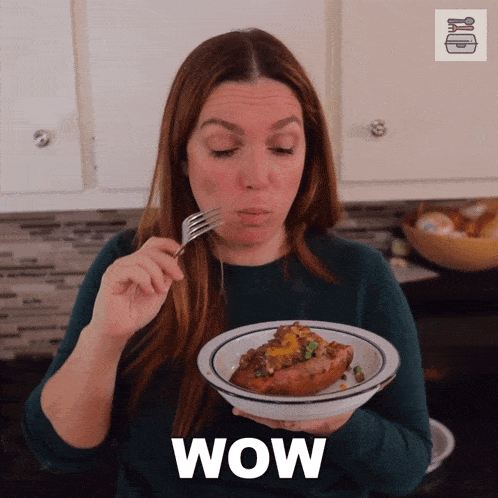 a woman is holding a plate of food and the word wow is on the bottom right