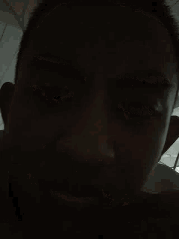 a close up of a man 's face with his eyes closed and his mouth open