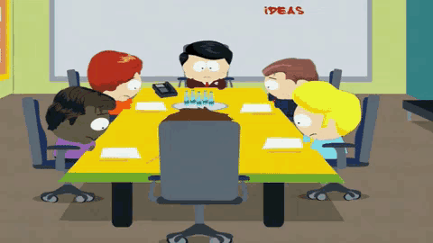 a group of people sitting around a table with a white board that says ideas on it