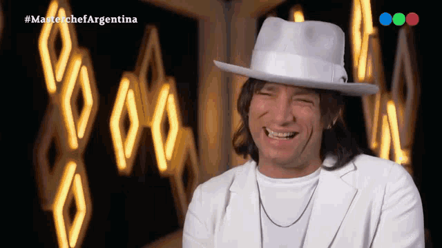 a man in a white hat is smiling in front of a master chef argentina logo