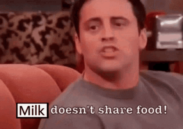 a man is sitting on a couch with the words milk does n't share food