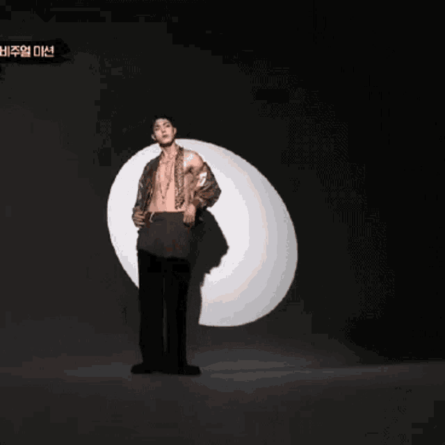 a man without a shirt is standing in front of a large white circle ..