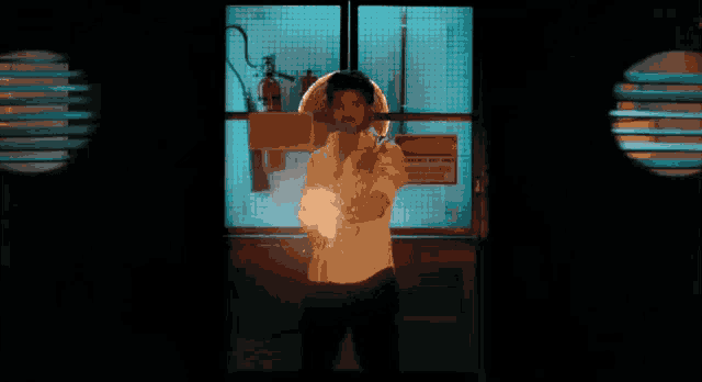 a man in a white shirt is holding a fire extinguisher in front of a notice sign