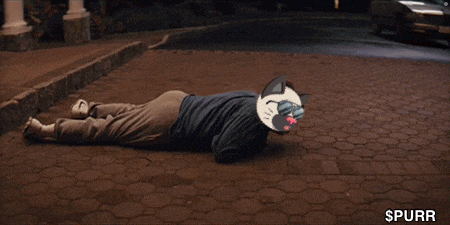 a person laying on the ground next to a white car with the word spurr on the bottom right