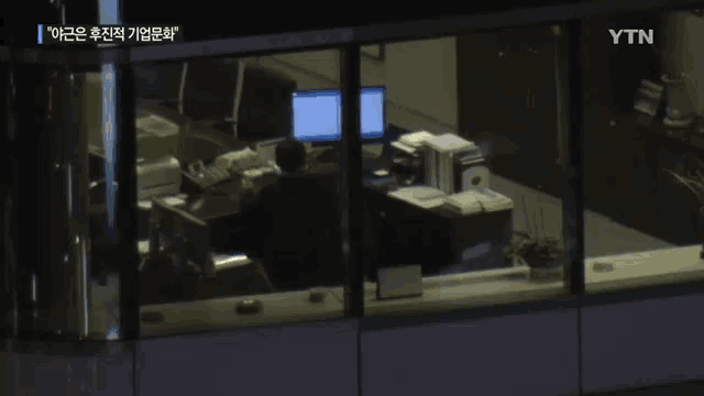 a ytn screen shows a dimly lit office