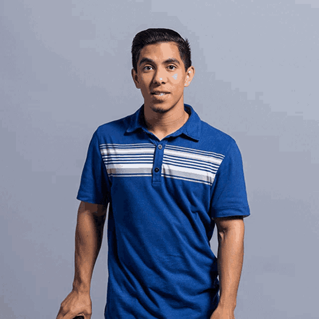 a man wearing a blue polo shirt with white stripes on the front
