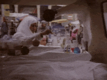 a woman in a white hijab is pouring liquid into a glass