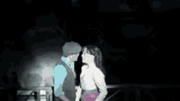 a man and a woman are hugging and kissing on a stage .