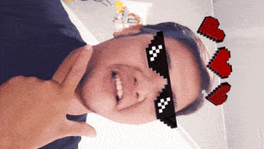 a man wearing pixelated glasses with hearts around his neck