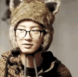 a man wearing glasses and a furry hat with ears is looking at the camera .