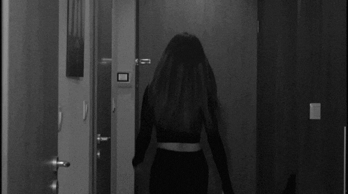 a black and white photo of two people standing in a hallway