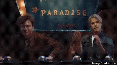 two people sitting in front of a sign that says paradise
