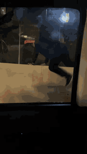 a reflection of a person in a car window with a sticker that says ' a ' on it