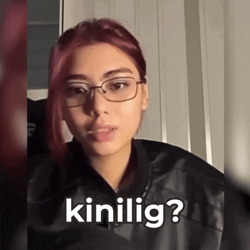 a woman wearing glasses and a black jacket is asking the question " kinilig "