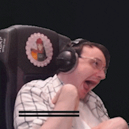 a man wearing headphones and glasses is sitting in a chair with his mouth open