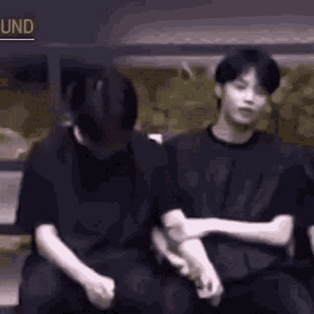 a group of young men are sitting next to each other and hugging .