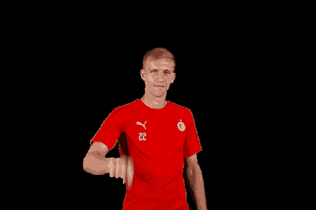 a man wearing a red puma shirt with the number 22 on it