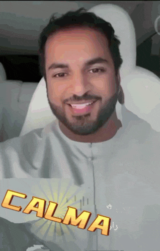 a man with a beard is sitting in a car with the word calma behind him