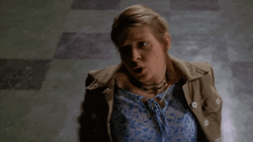 a woman in a tan jacket is holding her hands out