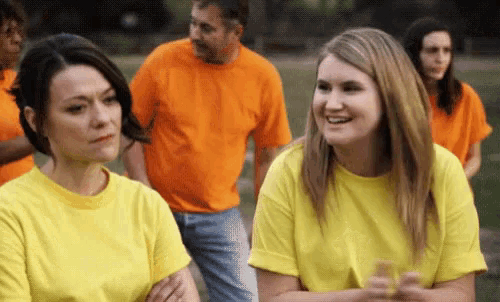 a group of people wearing orange shirts are standing in a line