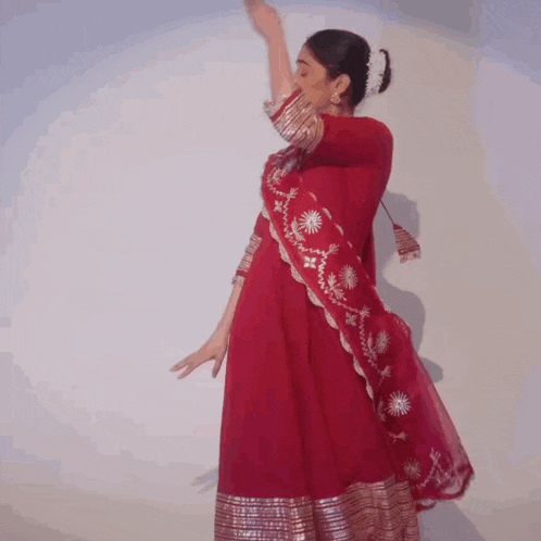 a woman in a red dress is dancing