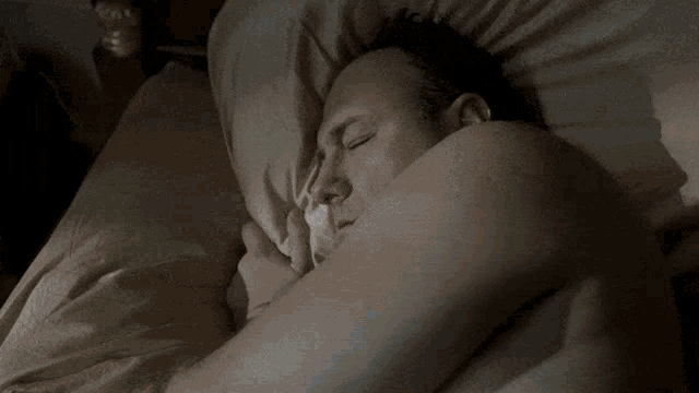 a blurry picture of a person laying on a bed with their legs crossed