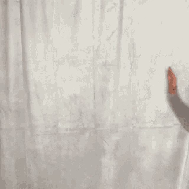 a woman with long red hair is standing in front of a white wall with her mouth open