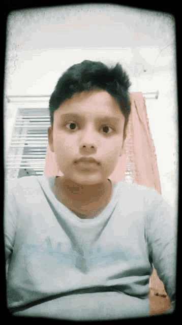 a young boy wearing a shirt that says adidas on it