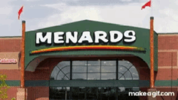 the front of a menards store has a green awning over the entrance