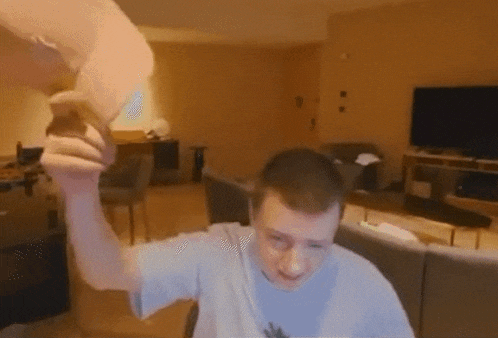 a man is sitting on a couch in a living room holding a piece of paper in his hand .