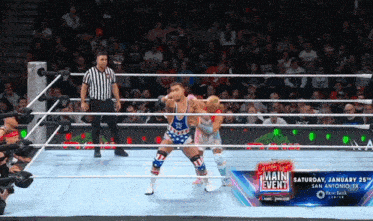 two wrestlers in a wrestling ring with a main event advertisement behind them