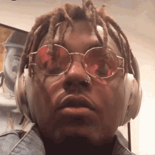 a man wearing headphones and sunglasses is making a funny face .